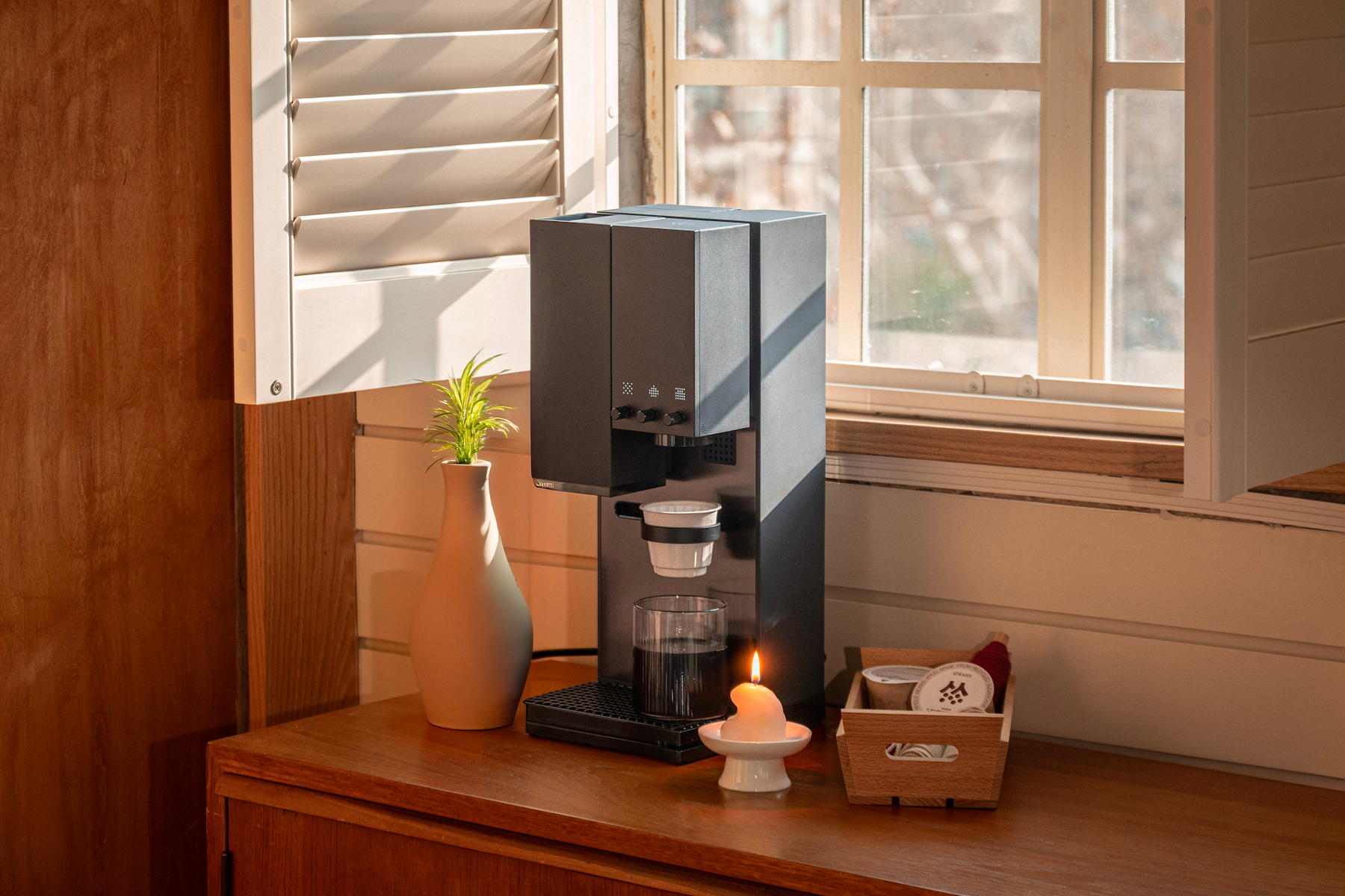 xBloom Studio in Midnight Black brewing on a wooden counter by a window